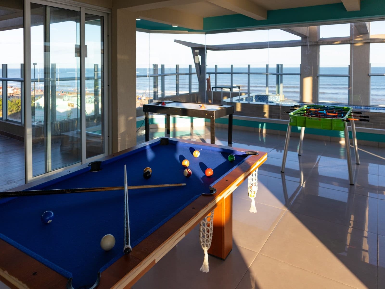 Sala de juegos con pool, futbolín y aire-hockey, vista al mar