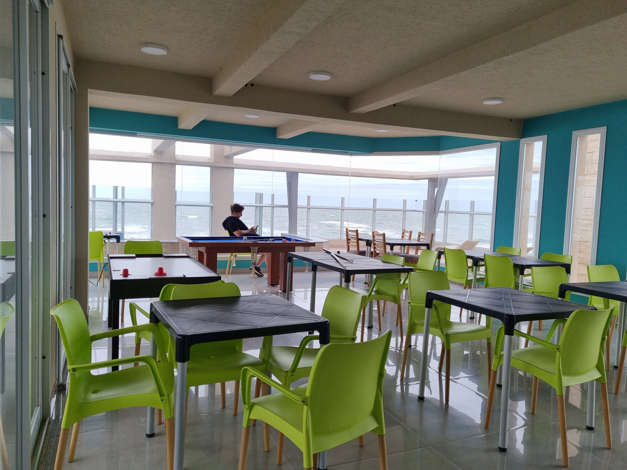 Sala de juegos con pool, futbolín y aire-hockey, vista al mar